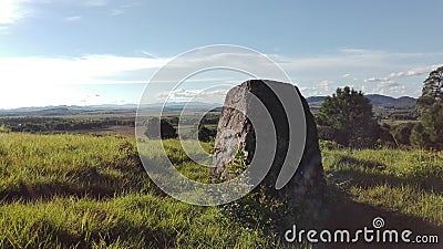 A shaped hewn stone standing on a green meadow Stock Photo