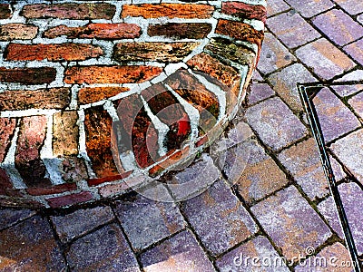 Shaped red brick park seat. aged, deteriorating and spalling weathered brick material. Stock Photo