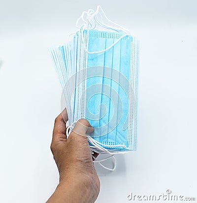 Sharing disposable surgical masks or blue colored new medical masks. COVID-19 prevention. H1N1, H5N1 safetymeasures.. Stock Photo