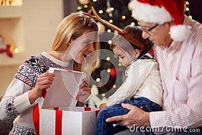 Sharing gift on Christmas- smiling mother giving present to son Stock Photo