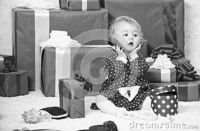 Sharing joy of baby first christmas with family. Little baby girl play near pile of gift boxes. Gifts for child first Stock Photo