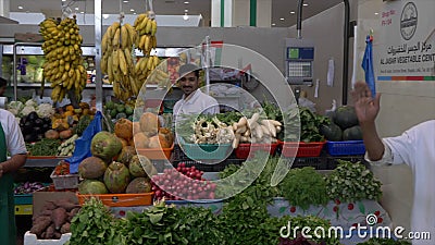 Sharja, UAE - enero de 2018: vendedor que vende verduras frescas y verdes en el mercado local de la comida en la ciudad UAE de Sh almacen de metraje de vídeo Sharja, UAE - enero de 2018: vendedor que vende verduras frescas y verdes en el mercado local de la comida en la ciudad UAE de Sh almacen de metraje de vídeo