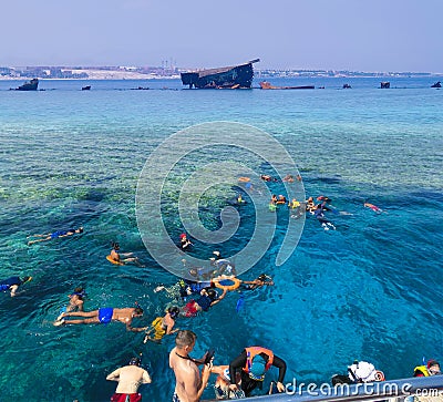 Sharm El Sheikh, Egypt - September 10, 2020: A group of tourists swims in the Red Sea near pleasure boats at Sharm El Sheikh, Editorial Stock Photo