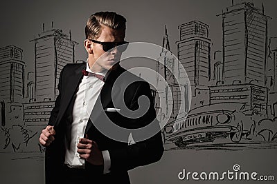 Sharp dressed man in black suit against city Stock Photo