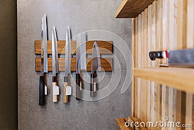 Sharp Japanese kitchen knives with empty price tag stick on magnet cover with wood on concrete wall Stock Photo