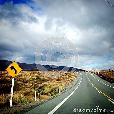 Sharp left bend in road for driving on Desert Road, New Zealand, NZ Stock Photo