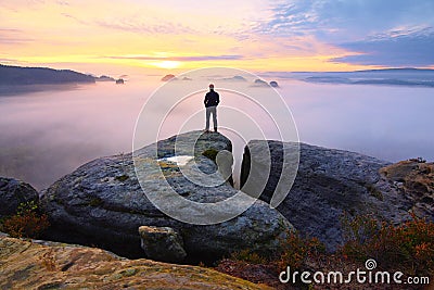 Sharp rear man silhouette on rocky peak. Satisfy hiker enjoy view. Tall man on rocky cliff Stock Photo