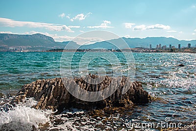 Sharp serrated rock standing surrounded by sea. Stock Photo