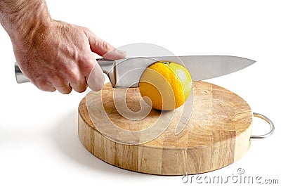 Sharp stainless steel knife cutting into orange Stock Photo