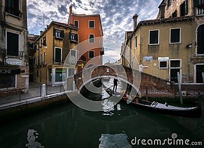 The sharp turns of the Venetian canals. A day in the life of gondoliers. Reflections in sea water. Venice. Italy Stock Photo