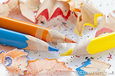Sharpened orange, yellow, blue pencils and wood shavings, drawing concept Stock Photo