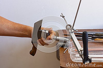 Sharpening metal knives by hand using a tool Stock Photo