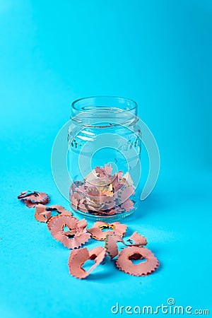 Sharpening shavings on glass isolated on blue background Stock Photo