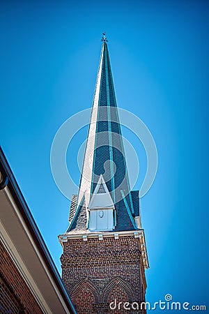 A sharply pointed church steeple against a clear blue sky. Stock Photo
