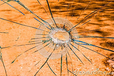 A shattered glass with an orange tint. Stock Photo