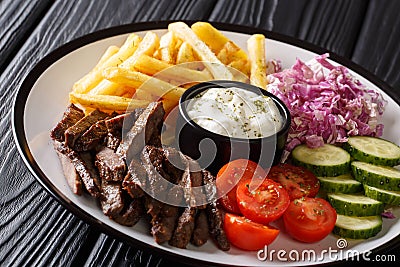 Shawarma bowl with lamb, vegetables, french fries and sauce close-up on a table. Horizontal Stock Photo