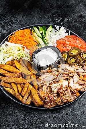 Shawarma Doner kebab on a plate with french fries and salad. Black background. Top view Stock Photo