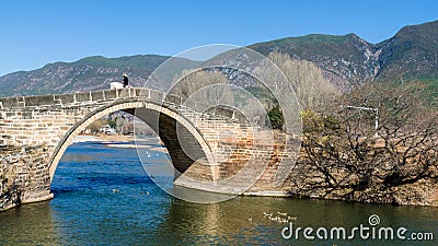 Horse rider crossing an old stone bridge in Shaxi, China Editorial Stock Photo