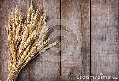 Sheaf of wheat ears on wooden table Stock Photo