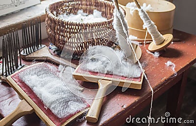 Sheep wool and carding brushes lying on table. Stock Photo