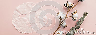 Sheet facial mask, eucalyptus and cotton flower on pastel pink paper background. Banner for web design. Skin care, dermatology, Stock Photo