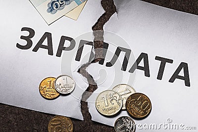 A sheet of paper with the inscription in Russian: salary, torn in half. There is no way to pay for the work done Stock Photo