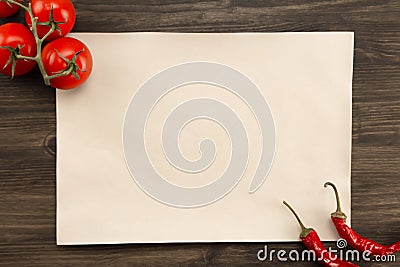 Sheet vintage paper with tomatoes and Chile peppers aged wooden background. Healthy vegetarian food. Recipe, menu, mock up, co Stock Photo