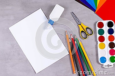 Sheets of paper, glue and scissors on a table Stock Photo