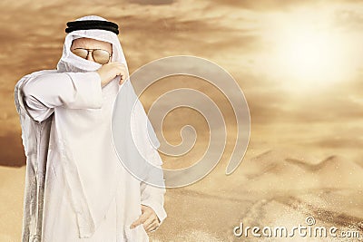 sheik protect with keffiyeh from desert storm in front of sunlight Stock Photo