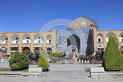 Sheikh Lotfollah Mosque mosque and arcade shops at Naqsh-e Jahan Square with horse carts and people in Isfahan, Iran. Editorial Stock Photo