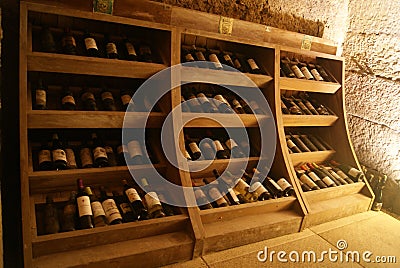 Shelf in wine cellar with old and dusty wine bottles Editorial Stock Photo