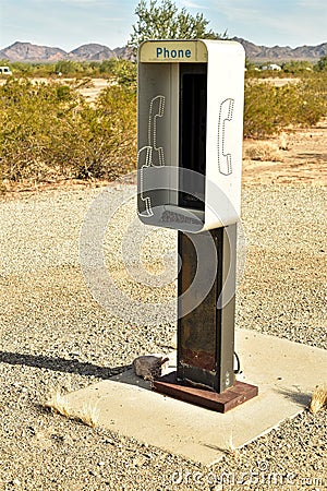 Empty telephone booth in desert outdated technology Stock Photo