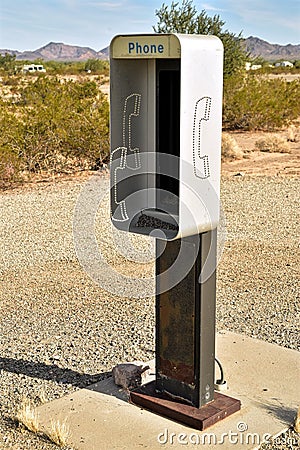 Empty telephone booth in desert outdated technology Stock Photo