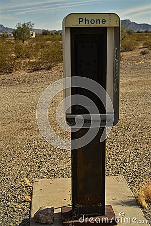 Empty telephone booth in desert outdated technology Stock Photo