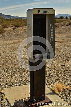 Empty telephone booth in desert outdated technology Stock Photo