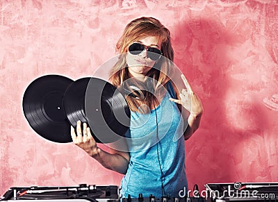 Shell keep you entertained. A young female dj gesturing and holding records. Stock Photo