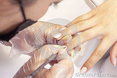 Shellac coating master applies nail polish to client Stock Photo