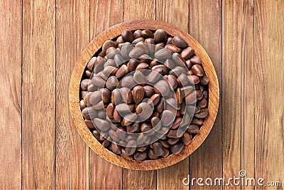 shelled pine nuts in bowl on wooden table background, top view. organic vegetarian food Stock Photo