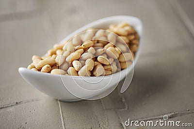 Shelled pine nuts in a white bowl Stock Photo