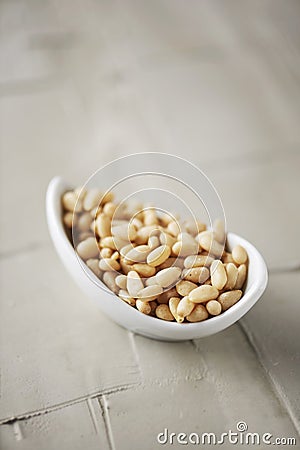 Shelled pine nuts in a white bowl Stock Photo