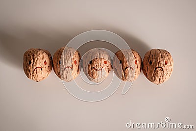 Shelled walnuts with stylized faces of smiling and grumpy faces on it. Being happy and sad. Customer Experience Concept Stock Photo