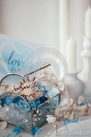 Shells, blue and white crystals in a glass box, candles Stock Photo