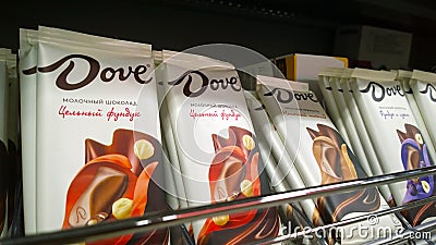 Shelves with famous brand milk chocolate Dove. Delicious Candy with nuts. Aisle in supermarket. Promotion. Retail industry. Editorial Stock Photo