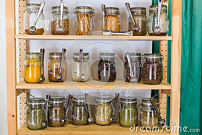 Shelves with a selection of spices and grains in glass jars in zero waste shop Stock Photo