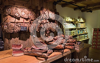Shelves with typical Italian sausages prosciutto, speck inside a grocery market Editorial Stock Photo