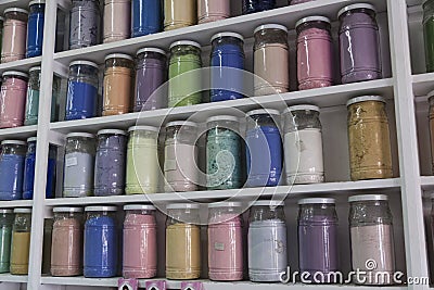 Shelving with glass jars of colorful pigments Stock Photo