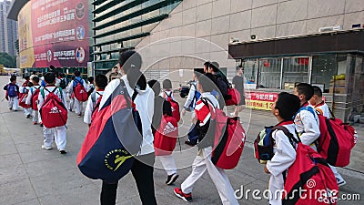 Shenzhen, China: children athletes walk past the sports square to take part in a competition Editorial Stock Photo