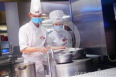 Shenzhen, China: male and female chefs cook in the kitchen Editorial Stock Photo