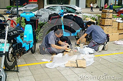 Shenzhen, China: on the sidewalk courier company employees are distributing customer courier Editorial Stock Photo