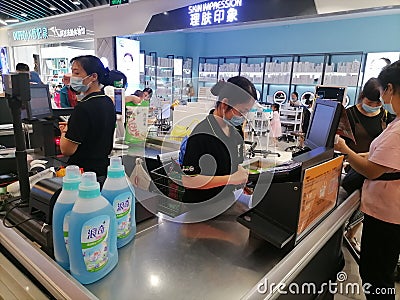 Shenzhen, China: Supermarket cashier is checking customers, this customer gives banknotes; there are few customers who give paper Editorial Stock Photo